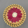 A photograph of the lid of the quillbox showing the fuchsia and white floral design with green accents, and the sweetgrass rim held in place with black cotton thread.
