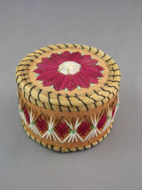 A photograph of the quillbox showing the lid and body. There is a fuchsia and white floral design on the lid, and fuchsia and white geometric patterns on the body.
